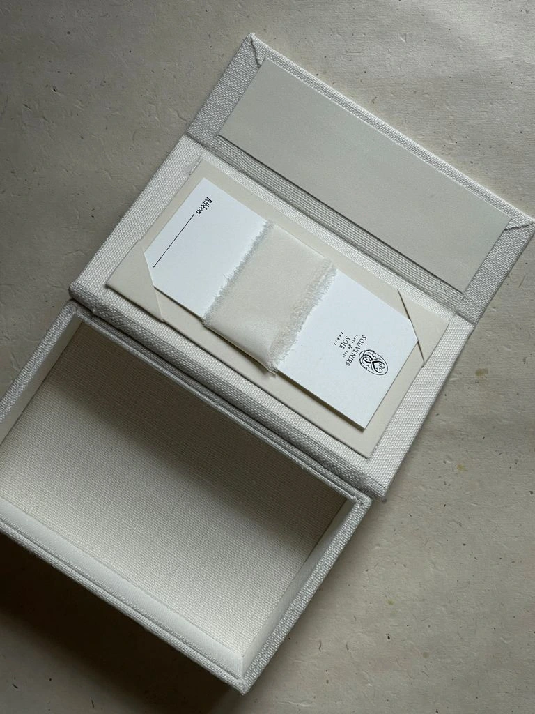 A slim pocket notebook in stone grey with burgundy elastic.